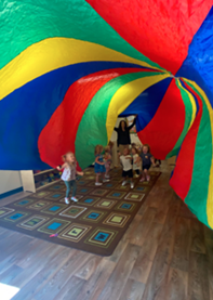 A group of children standing under a large colorful tent
AI-generated content may be incorrect.