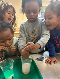 A group of children playing with liquid in a cup
AI-generated content may be incorrect.